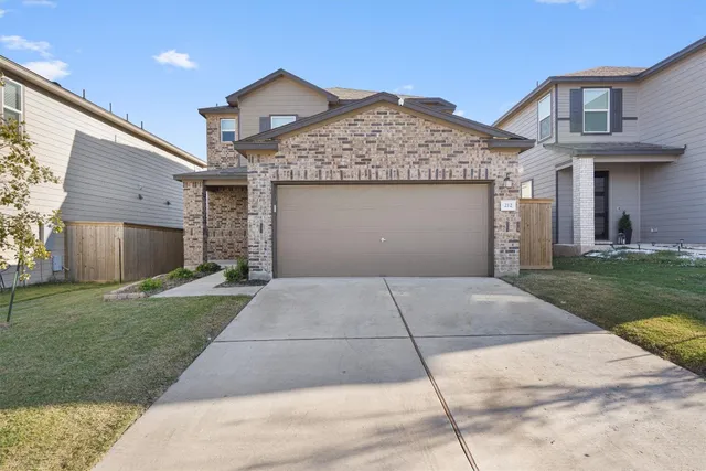 a front view of a house with a yard and a garage