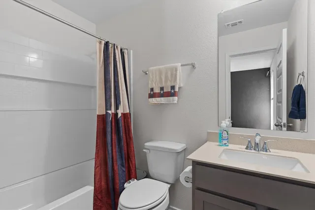 a bathroom with a sink a toilet a mirror and shower