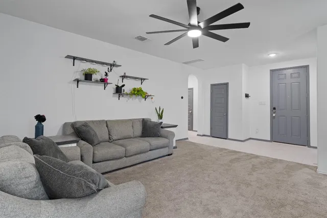 a living room with furniture and a ceiling fan