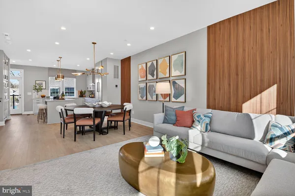 a dining room with stainless steel appliances kitchen island granite countertop a dining table chairs and a refrigerator
