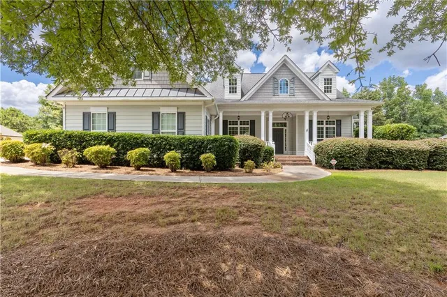 a front view of a house with porch and garden