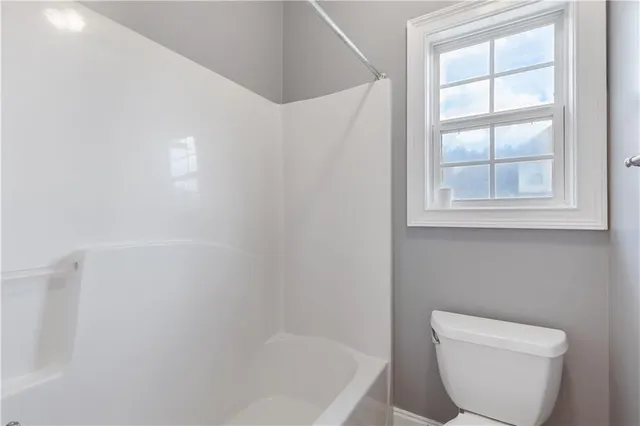 a white toilet sitting next to a window