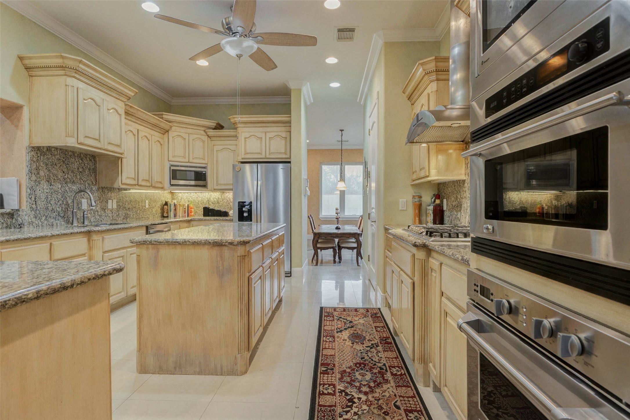 2732 Broadway Street Dickinson, TX 77539 - Photo 9 of 50 a kitchen with stainless steel appliances kitchen island granite countertop a stove a sink and a microwave