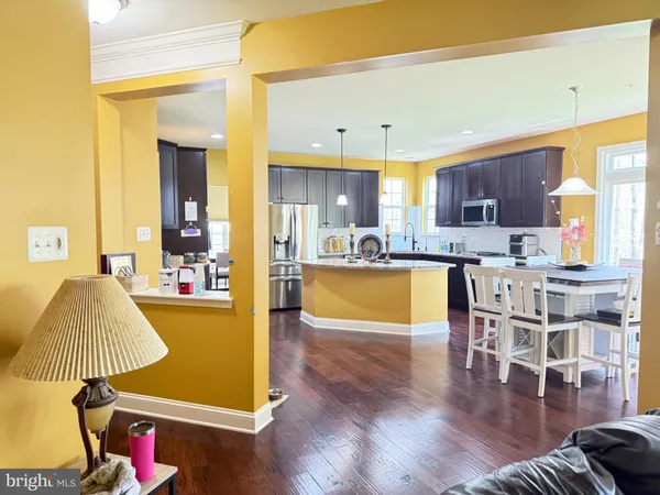 a kitchen with a sink and a stove with wooden floor