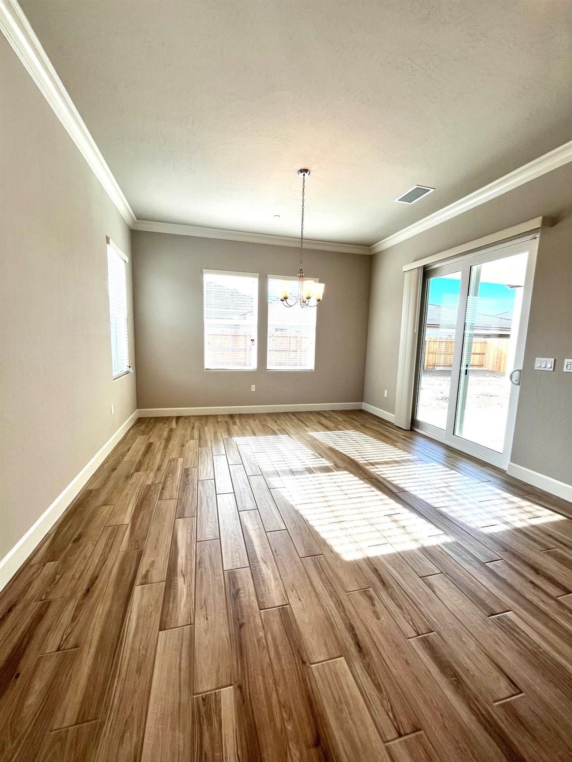 682 Bloom Lane Clovis, CA 93619 - Photo 13 of 30 an empty room with wooden floor and windows
