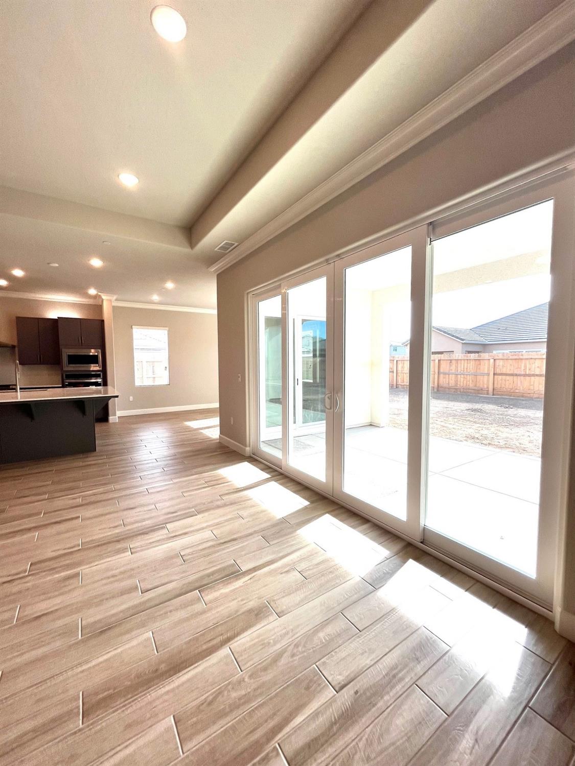682 Bloom Lane Clovis, CA 93619 - Photo 14 of 30 a view of an empty room with wooden floor and a window