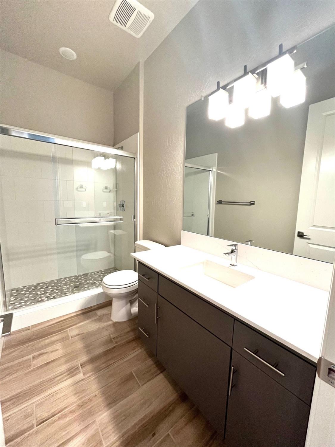 682 Bloom Lane Clovis, CA 93619 - Photo 20 of 30 a bathroom with a sink a toilet a large mirror and shower