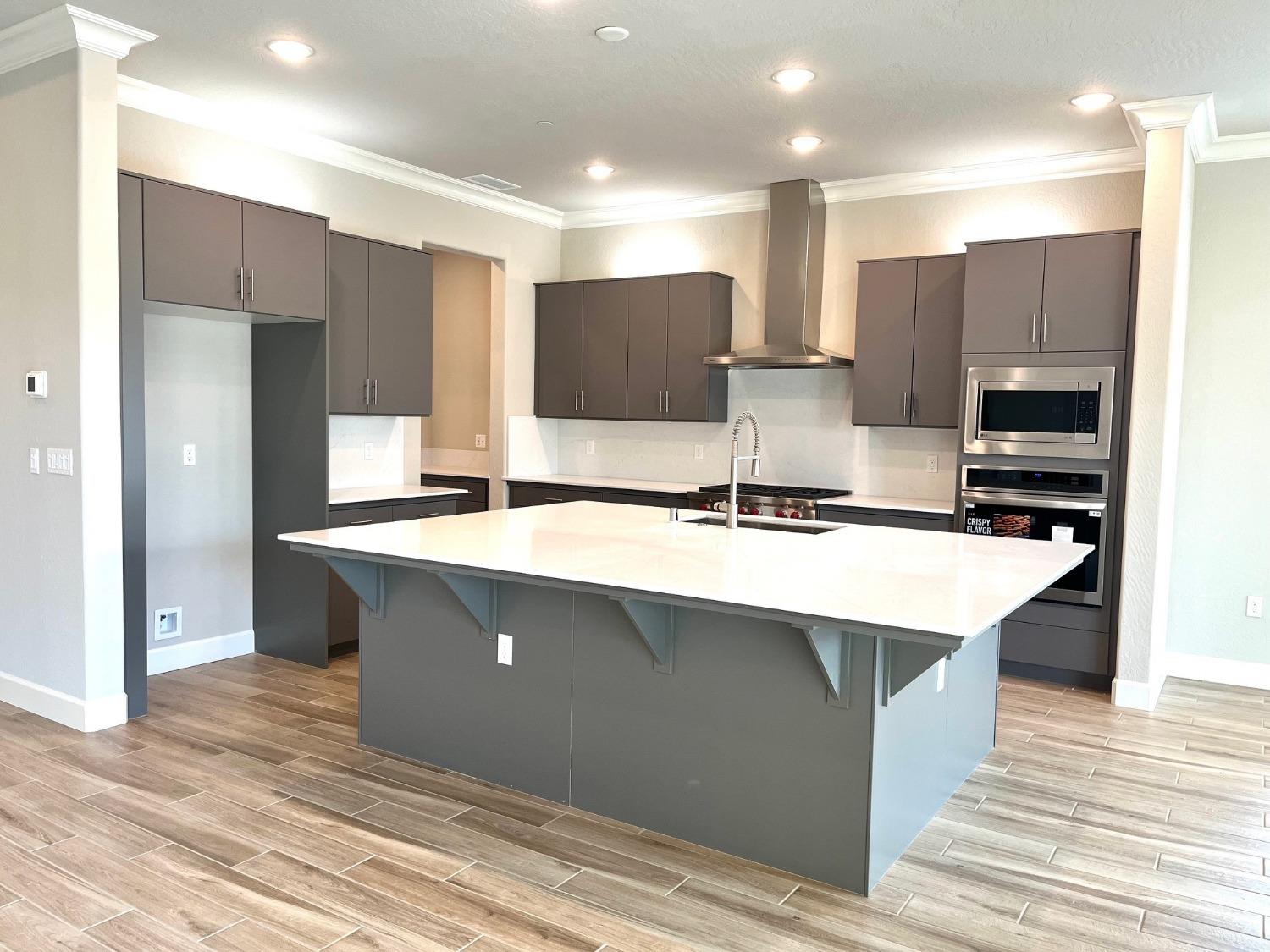 682 Bloom Lane Clovis, CA 93619 - Photo 4 of 30 a kitchen with stainless steel appliances a sink and refrigerator