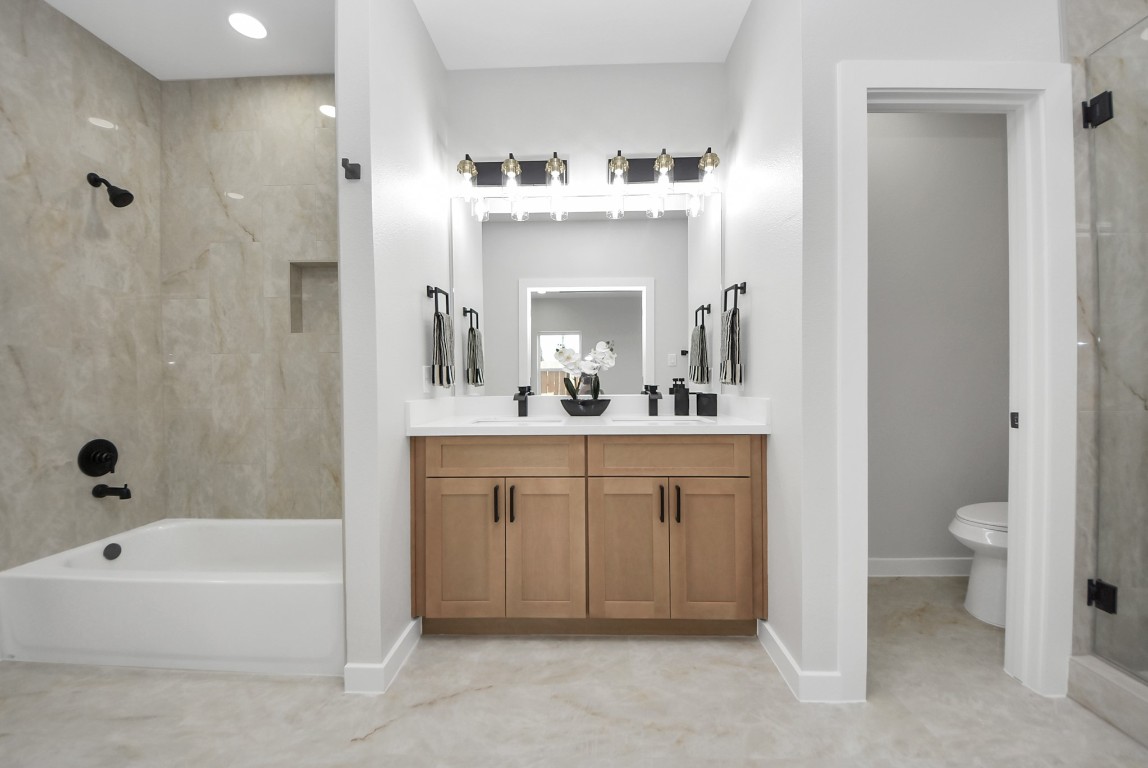 9826 Nedwald Street Houston, TX 77029 - Photo 14 of 50 a spacious bathroom with a bathtub sink mirror and toilet