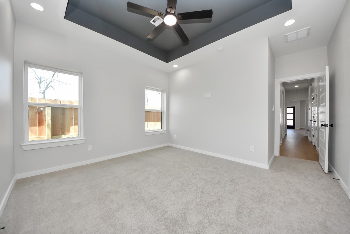 9826 Nedwald Street Houston, TX 77029 - Photo 22 of 50 an empty room with chandelier fan and windows