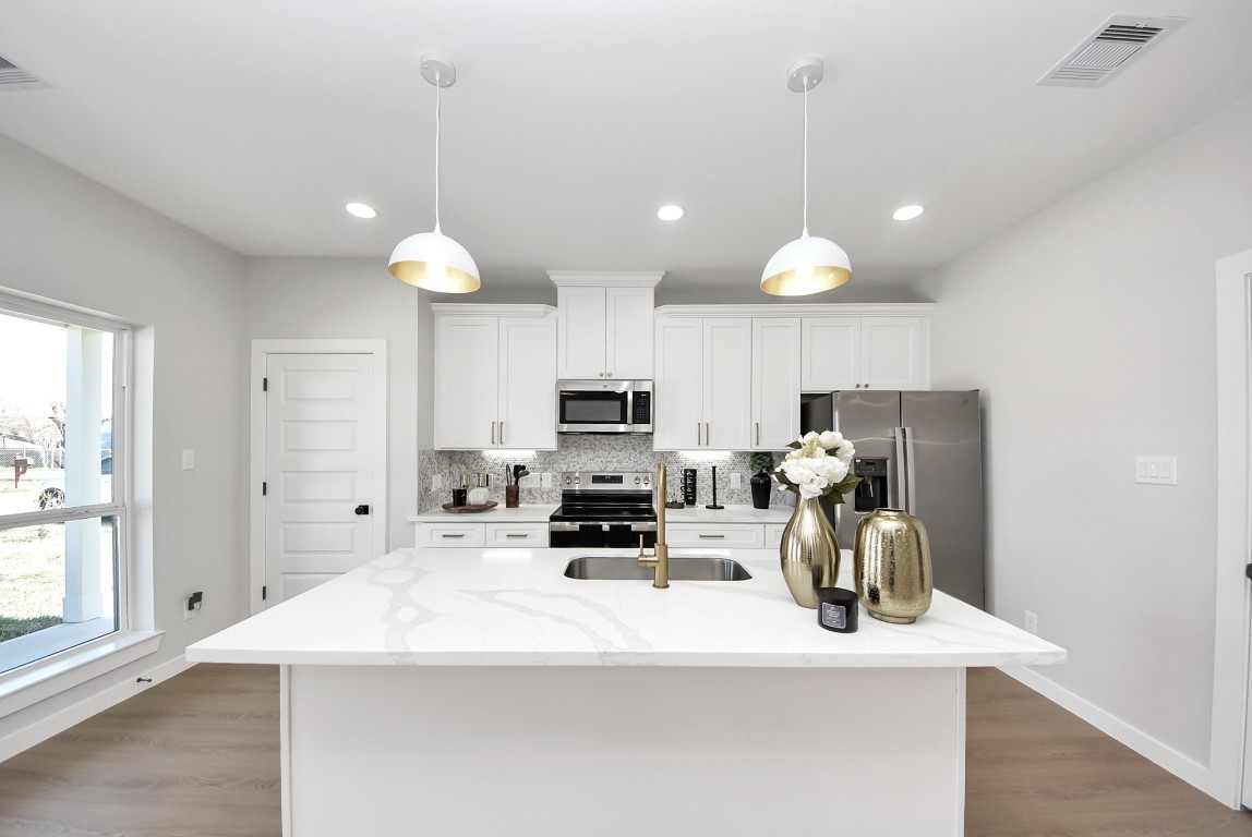9826 Nedwald Street Houston, TX 77029 - Photo 27 of 50 a kitchen with kitchen island a sink stainless steel appliances and cabinets