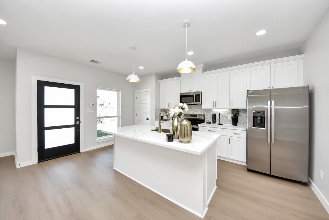9826 Nedwald Street Houston, TX 77029 - Photo 28 of 50 a kitchen with white cabinets and stainless steel appliances