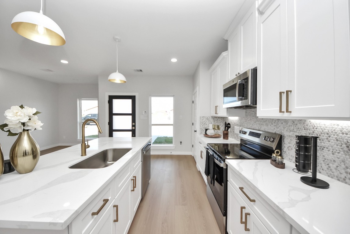 9826 Nedwald Street Houston, TX 77029 - Photo 33 of 50 a kitchen with kitchen island granite countertop a sink a counter space appliances and cabinets