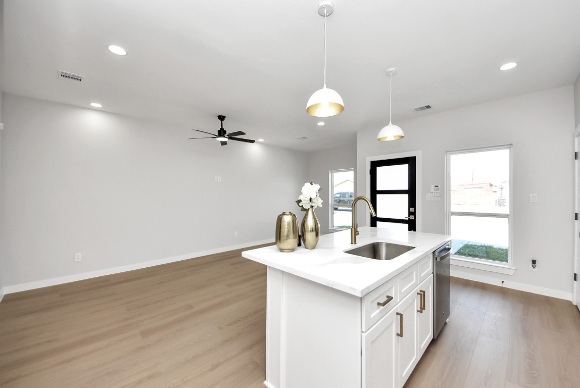 9826 Nedwald Street Houston, TX 77029 - Photo 34 of 50 a kitchen with a sink cabinets and wooden floor
