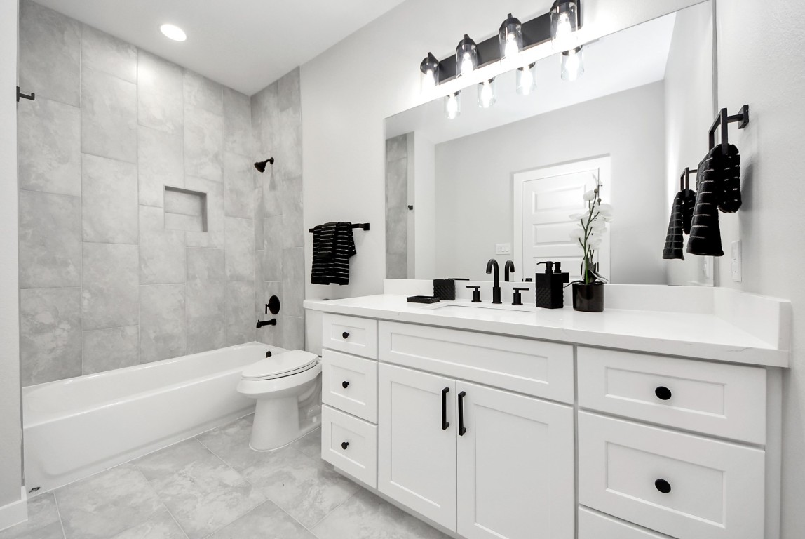 9826 Nedwald Street Houston, TX 77029 - Photo 45 of 50 a bathroom with a toilet a sink a mirror a bathtub and vanity