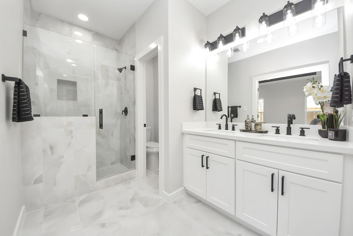 9826 Nedwald Street Houston, TX 77029 - Photo 46 of 50 a spacious bathroom with a shower sink and mirror