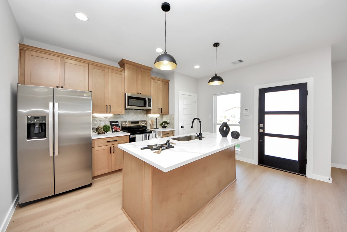 9826 Nedwald Street Houston, TX 77029 - Photo 6 of 50 a kitchen with stainless steel appliances granite countertop a refrigerator a stove a sink and a microwave