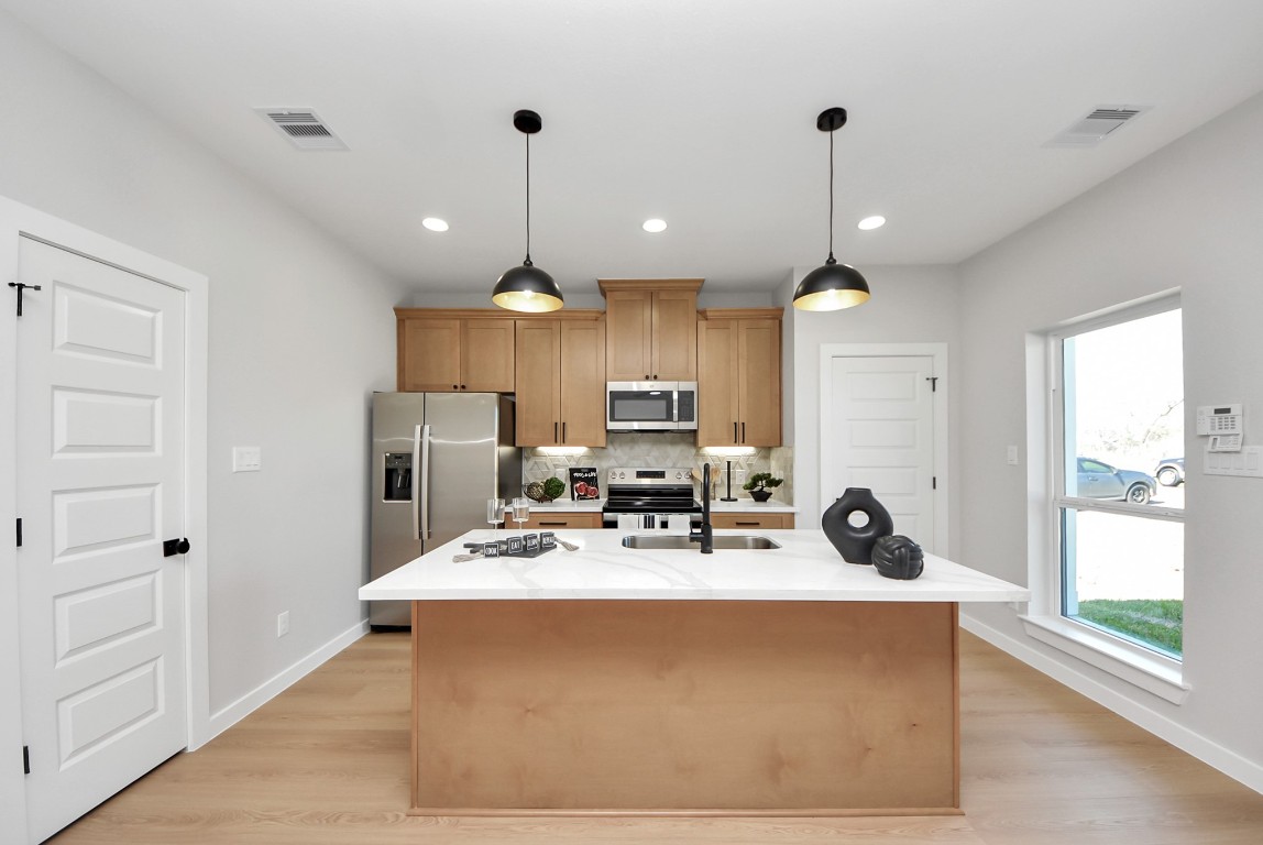 9826 Nedwald Street Houston, TX 77029 - Photo 7 of 50 a view of a kitchen with kitchen island stainless steel appliances a stove a sink a center island and windows