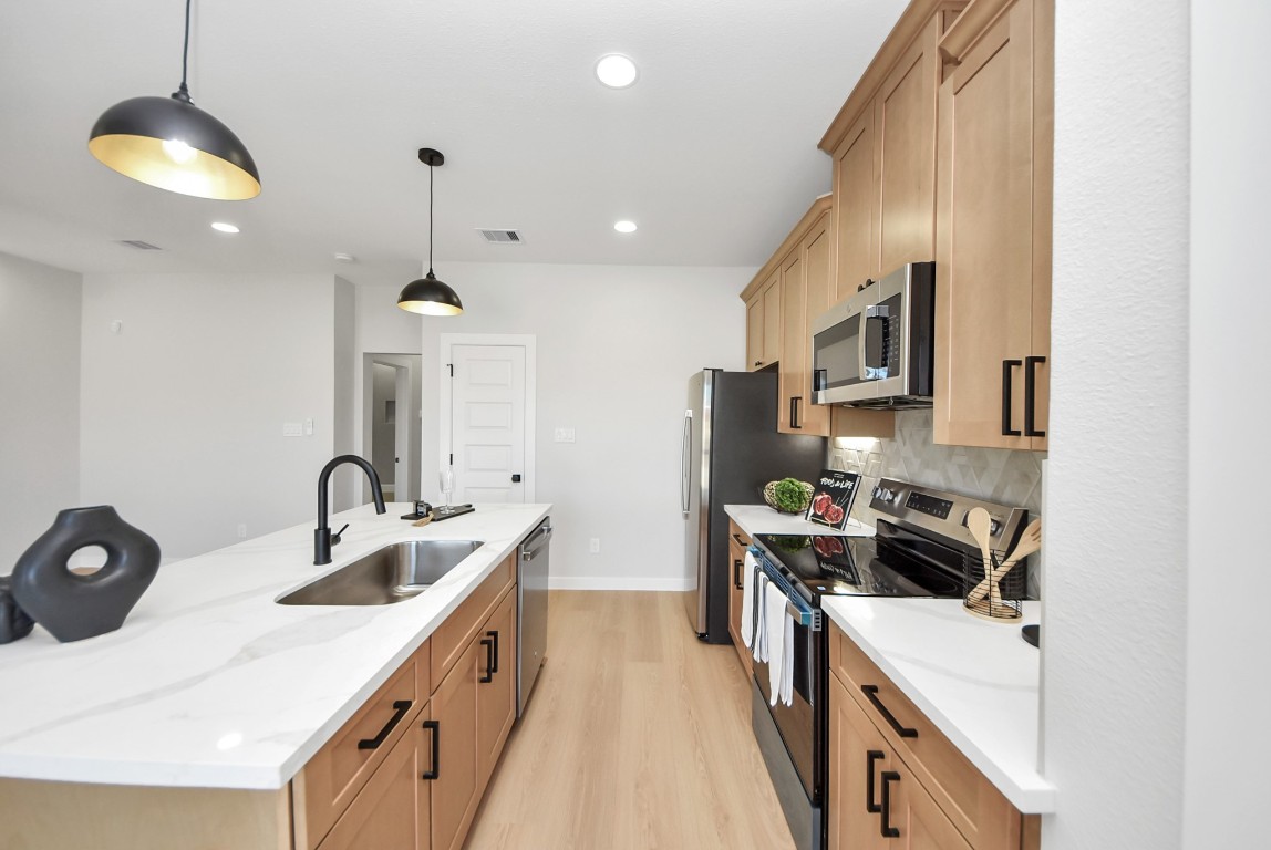 9826 Nedwald Street Houston, TX 77029 - Photo 10 of 50 a kitchen with a sink a stove and a refrigerator