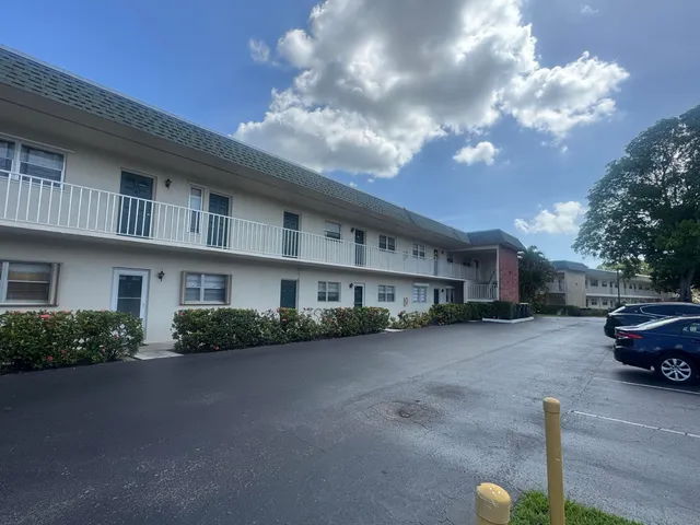 a front view of a house with yard and parking