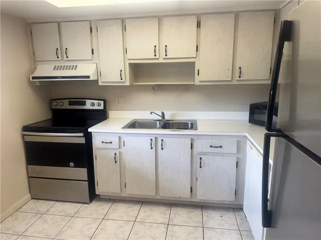 a kitchen with white cabinets and appliances