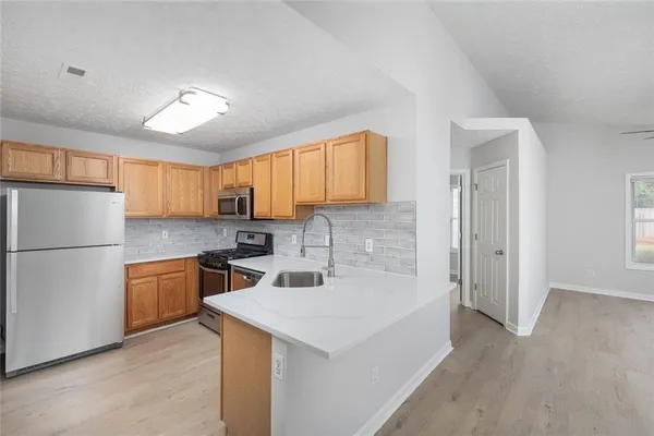 a kitchen with a refrigerator sink and cabinets