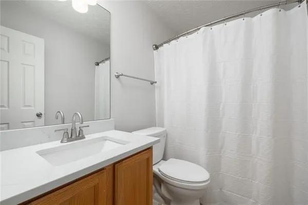 a bathroom with a sink a toilet and a mirror