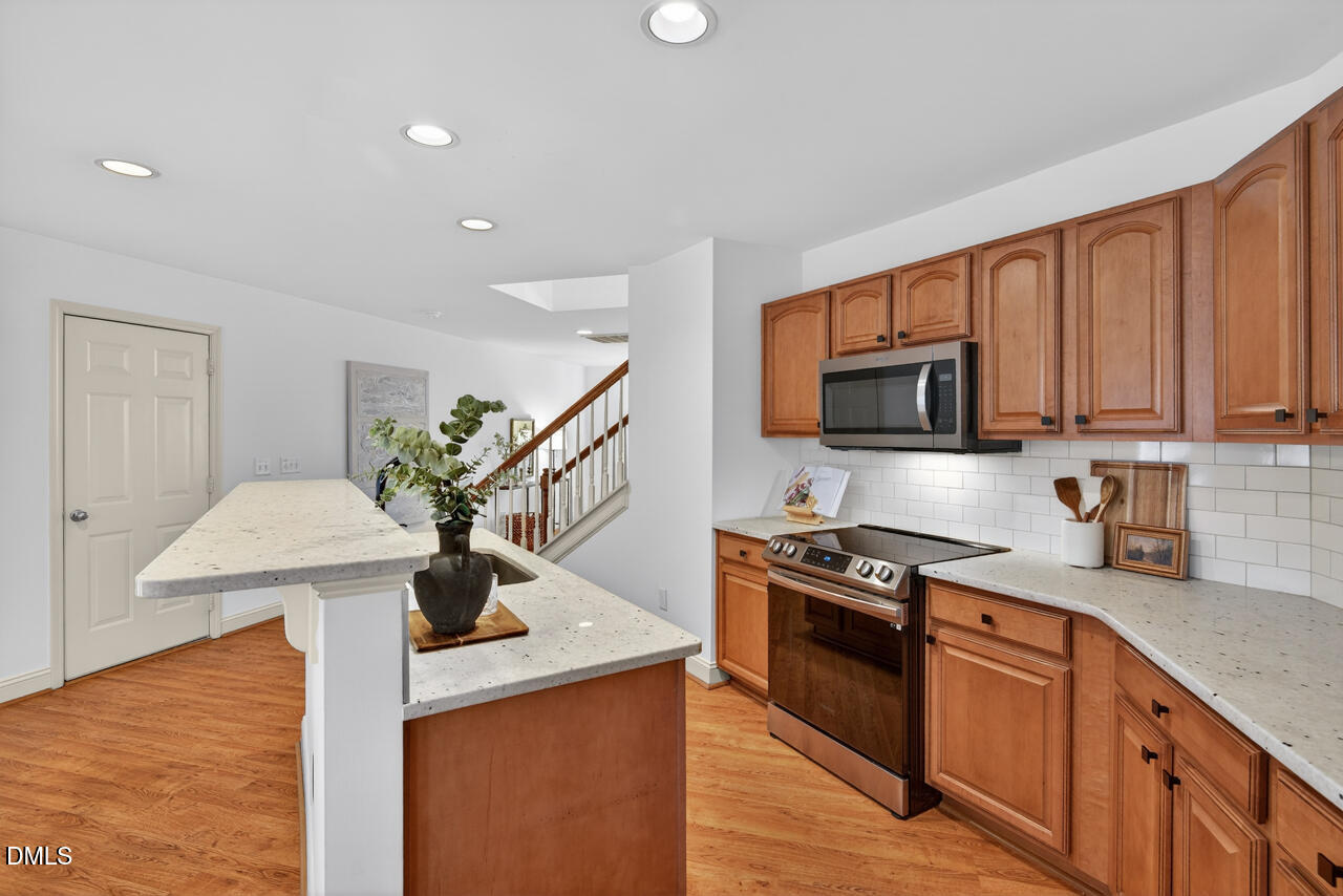548 Abbey Fields Loop Morrisville, NC 27560 - Photo 10 of 29 a kitchen with stainless steel appliances granite countertop a sink a stove top oven a counter space and cabinets