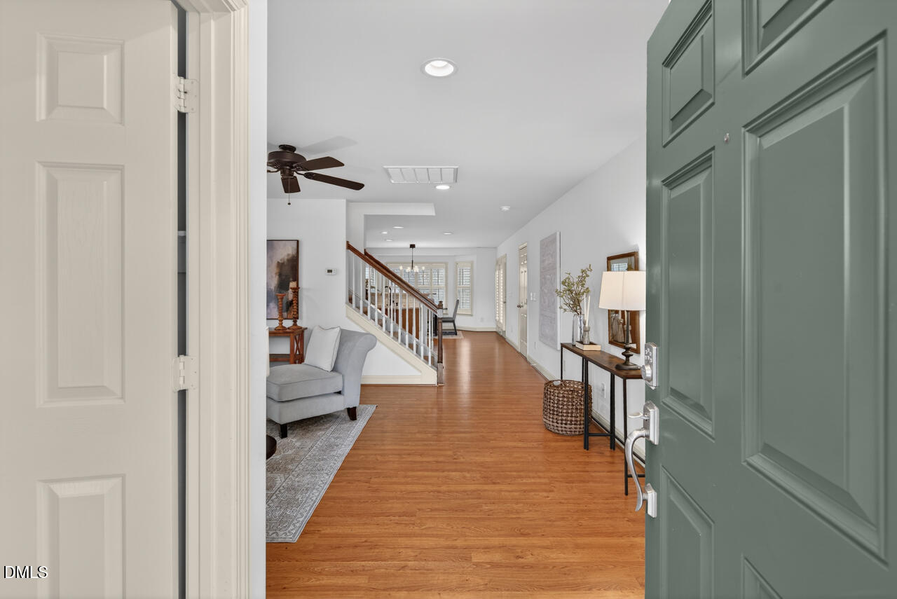 548 Abbey Fields Loop Morrisville, NC 27560 - Photo 3 of 29 a hallway with white walls and wooden floor