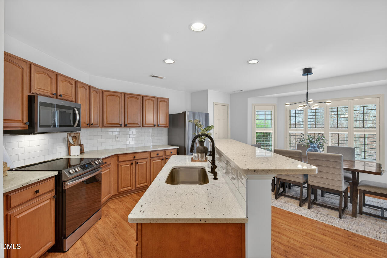 548 Abbey Fields Loop Morrisville, NC 27560 - Photo 9 of 29 a kitchen with granite countertop a sink a counter top space appliances and cabinets