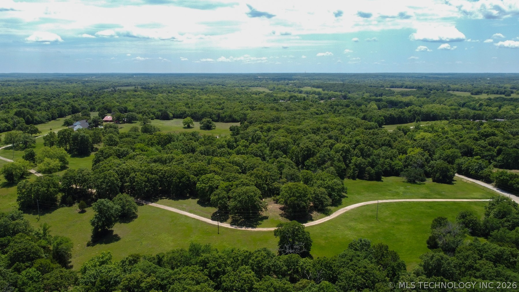 13248 North 3540th Road Maud, OK 74854 - Photo 27 of 98 Expansive, tree-lined landscape with multiple clearings and winding unpaved paths