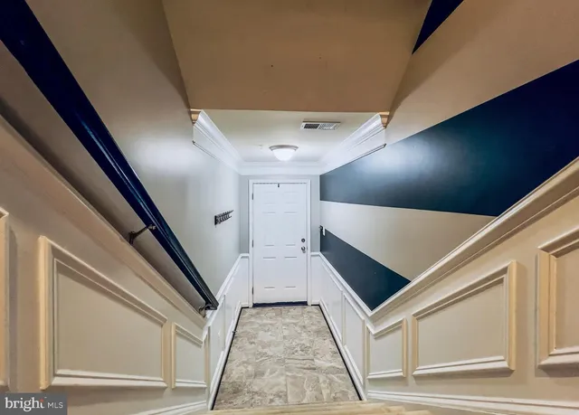 a view of an empty room with glass door and wooden floor