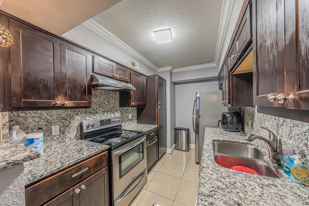 1807 East Grauwyler Road, Unit 124 Irving, TX 75061 - Photo 11 of 22 a kitchen with stainless steel appliances kitchen island granite countertop a sink stove and refrigerator