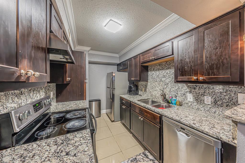 1807 East Grauwyler Road, Unit 124 Irving, TX 75061 - Photo 10 of 22 a kitchen with stainless steel appliances granite countertop a sink stove and refrigerator