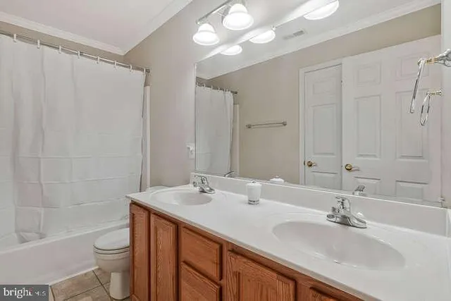 a bathroom with a double vanity sink toilet and shower