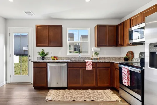 a kitchen with a sink cabinets stainless steel appliances and a window