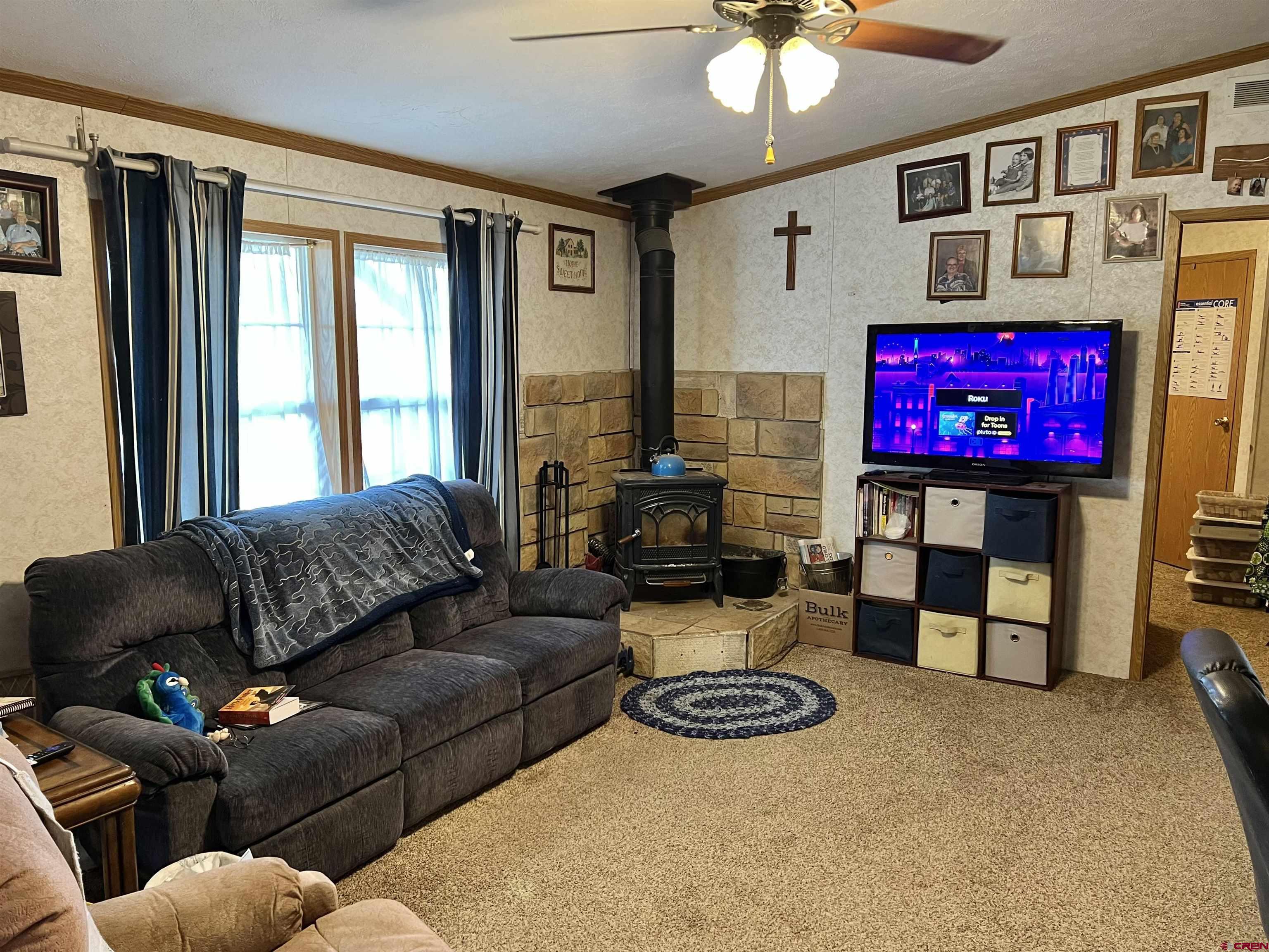 7692 6150th Road Montrose, CO 81401 - Photo 4 of 17 a living room with furniture a floor to ceiling window and a flat screen tv
