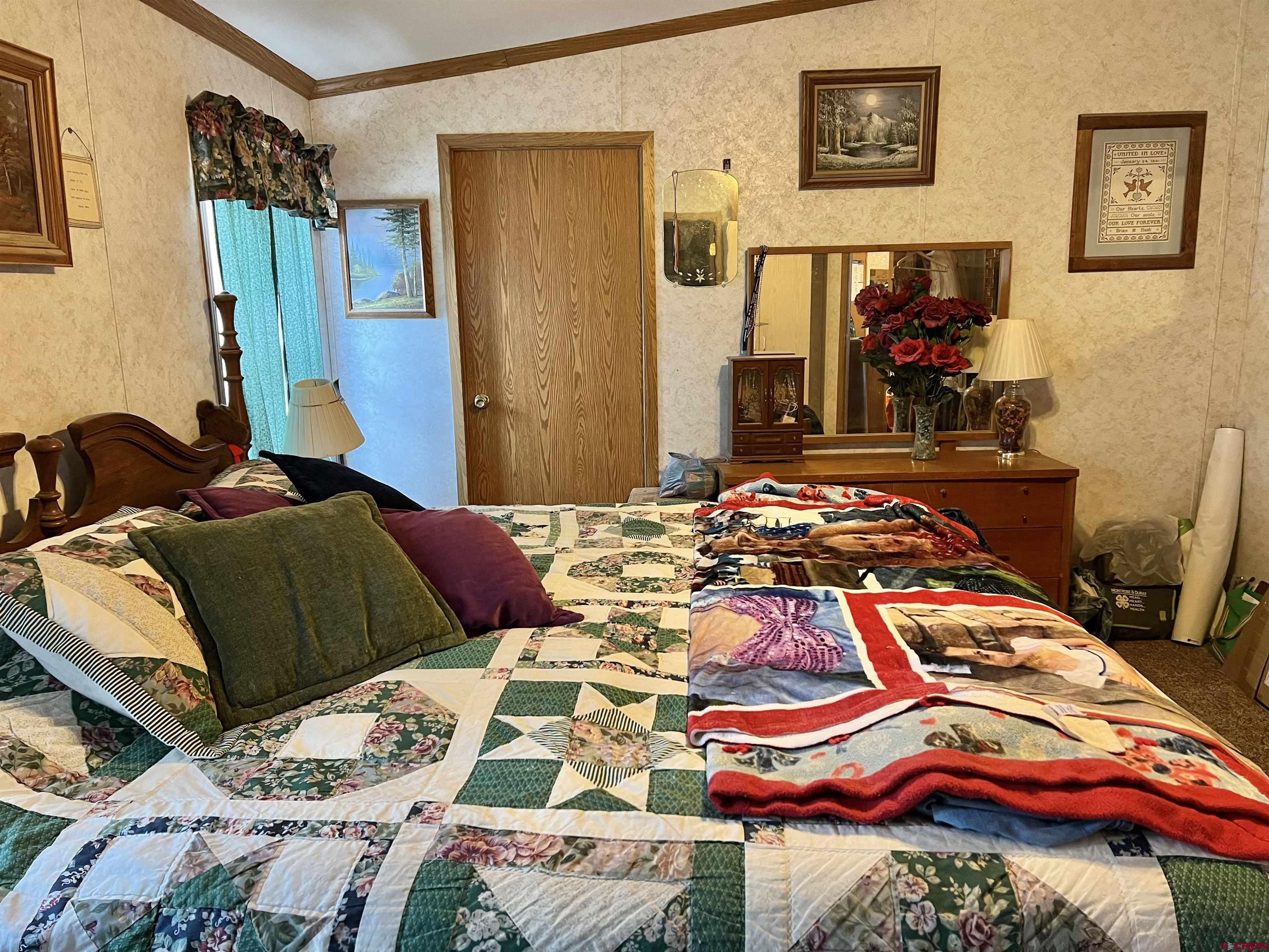 7692 6150th Road Montrose, CO 81401 - Photo 6 of 17 a bedroom with a bed and a painting on the wall