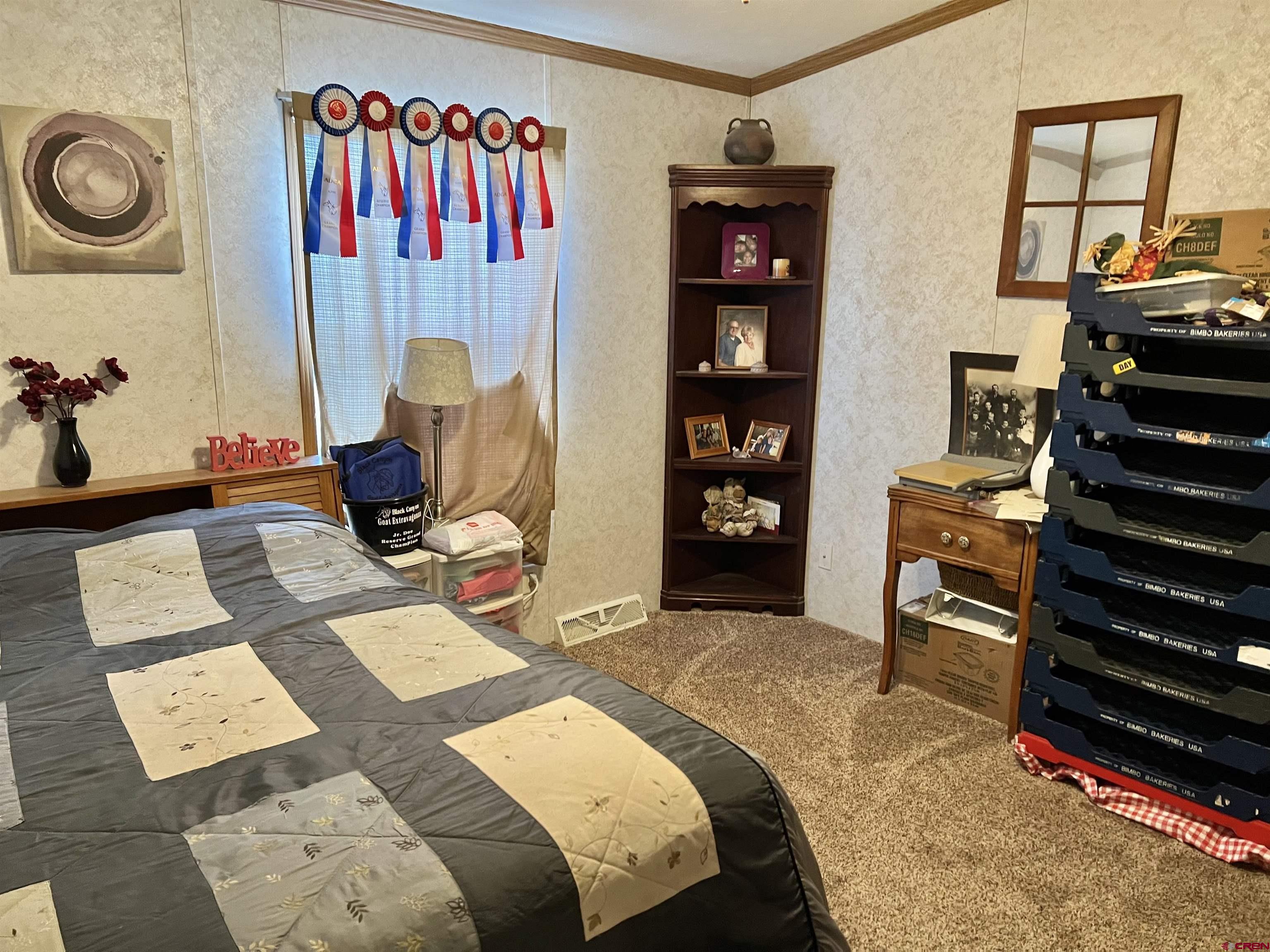 7692 6150th Road Montrose, CO 81401 - Photo 9 of 17 a bedroom with a bed and a bookshelf