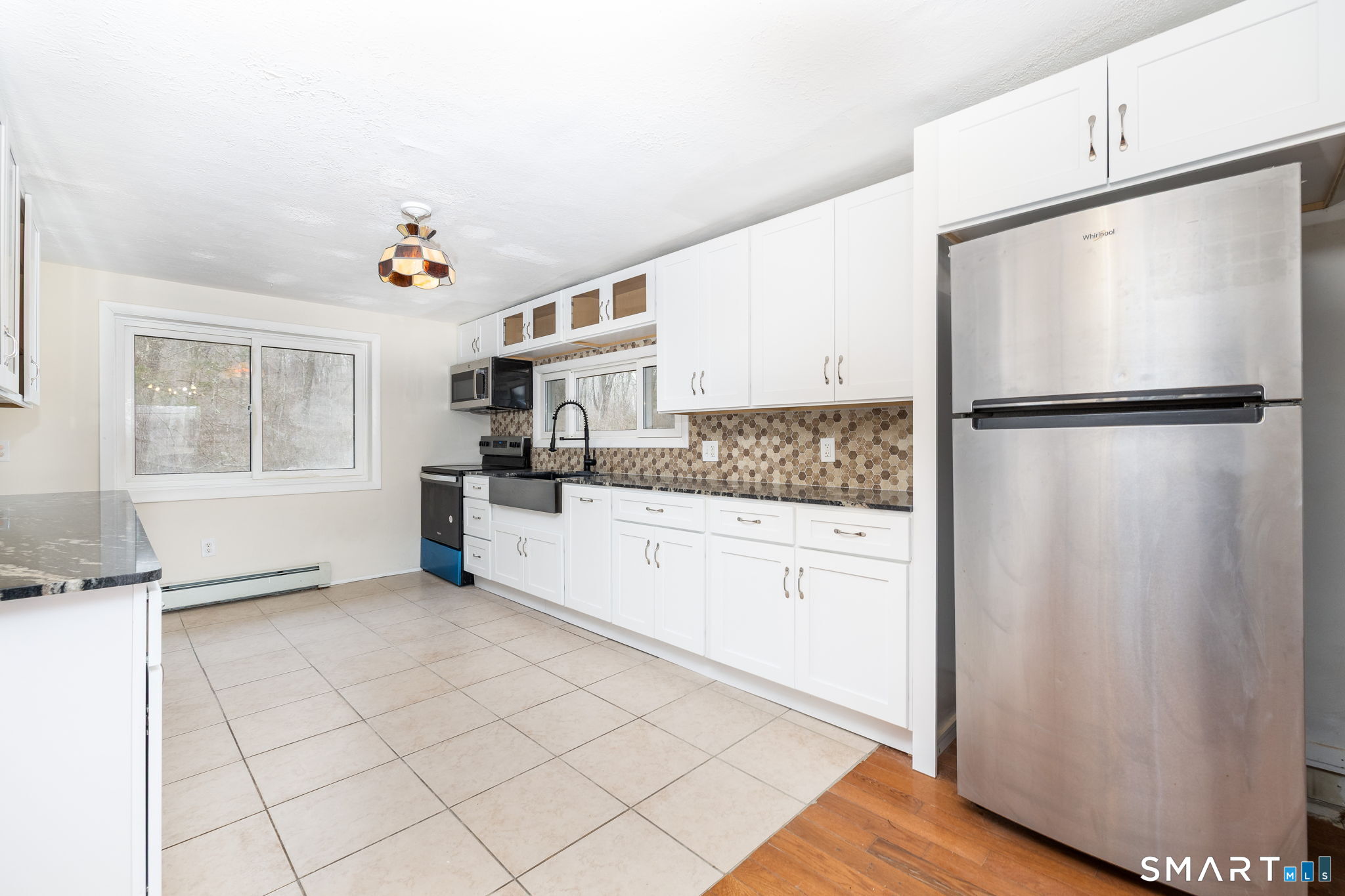 461 Pond Road Franklin, CT 06254 - Photo 11 of 35 a kitchen with a refrigerator a stove a sink and dishwasher with wooden floor