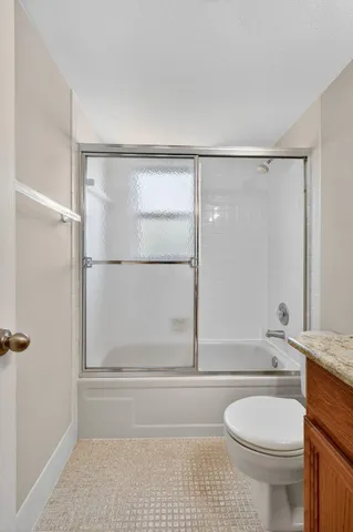 a bathroom with a granite countertop tub sink and mirror