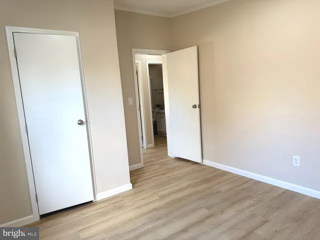 an empty room with wooden floor and entrance