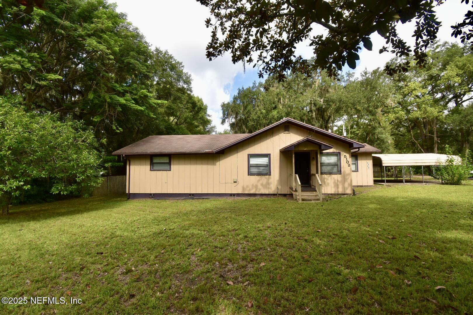 5102 Lambing Road Jacksonville, FL 32210 - Photo 1 of 25 a house with huge green field in front of it