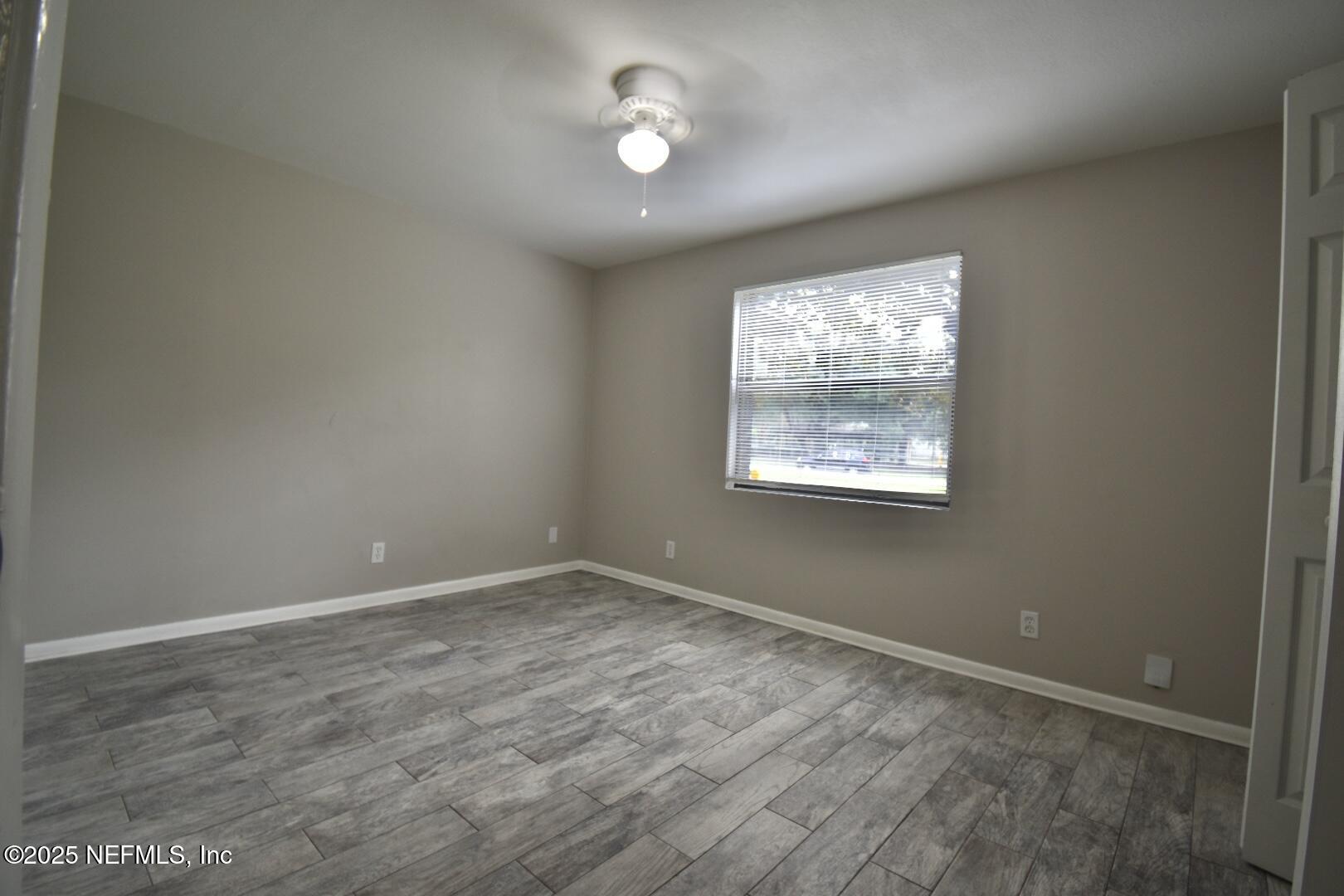 5102 Lambing Road Jacksonville, FL 32210 - Photo 16 of 25 an empty room with wooden floor and windows