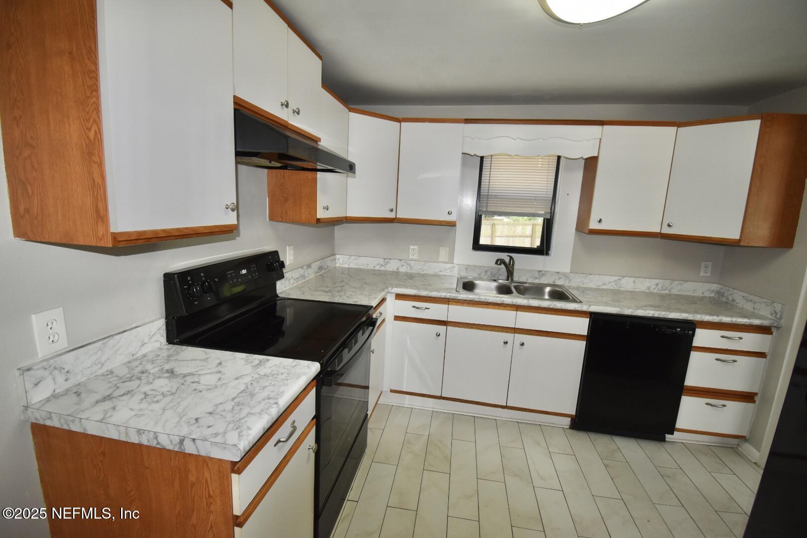 5102 Lambing Road Jacksonville, FL 32210 - Photo 10 of 25 a kitchen with a sink a stove top oven and white cabinets