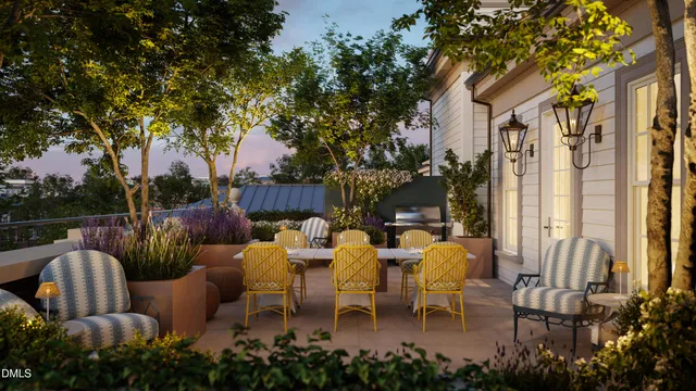 a view of a patio with table and chairs potted plants and large tree