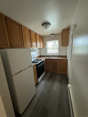 a kitchen with wooden cabinets and white appliances
