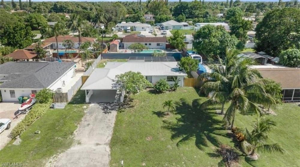 1948 46th Street Southwest Naples, FL 34116 - Photo 2 of 14 Single-story residence featuring a metal roof, an attached carport, and a partially fenced lot
