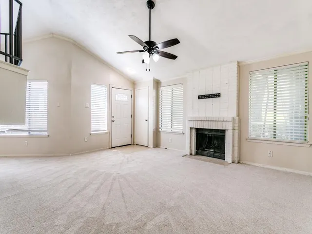 a view of empty room with fireplace and windows