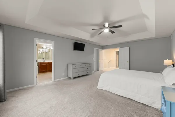 a spacious bedroom with a bed and a chandelier